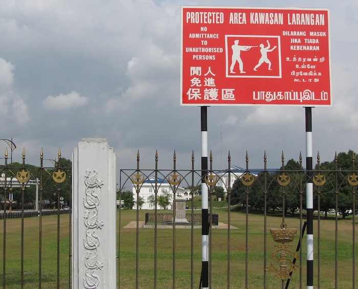 do not think of entering photo of sign showing gunman shooting someone, and warning in 5 languages not to enter