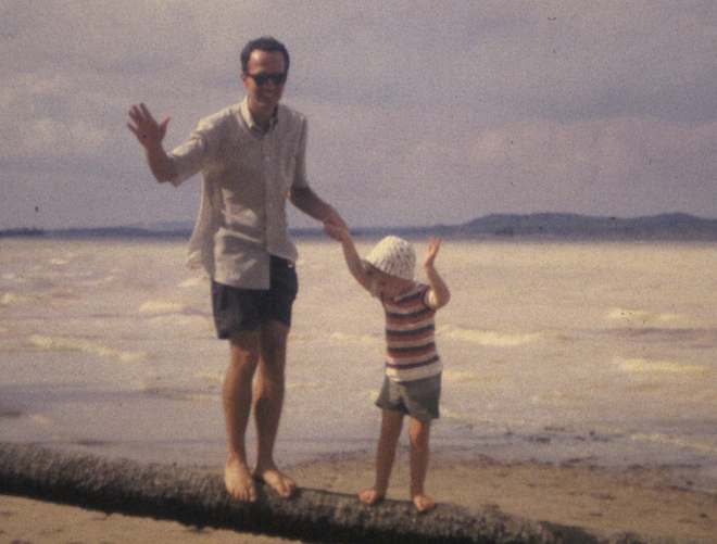 photo of Bill and John Hunter balancing on a log on a beach in Malaysia