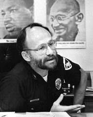 photo of David Couper in uniform with photos of Martin Luther King Jr. and Gandhi on his office wall.
